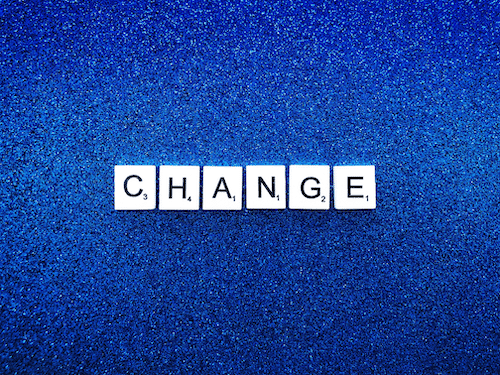 Change using Scrabble tiles on blue background.